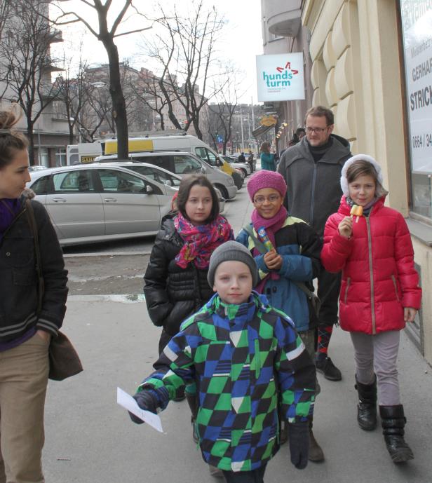 Eine Gruppe von Kindern und ein Mann gehen auf einem Bürgersteig entlang.