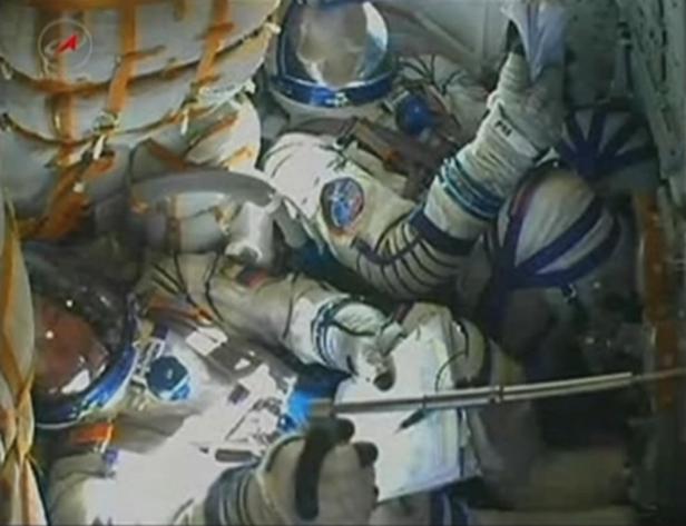 Mehrere Astronauten in Raumanzügen in einem Raumschiff.