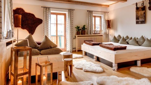Ein Schlafzimmer im Landhausstil mit zwei Betten und rustikalen Dekorationen.