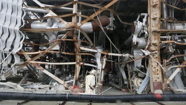 Das Innere einer zerstörten Industrieanlage mit verbogenen Metallstrukturen und Rohren.
