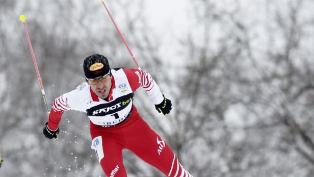 Ein Skilangläufer in roter und weißer Sportbekleidung während eines Wettkampfs.