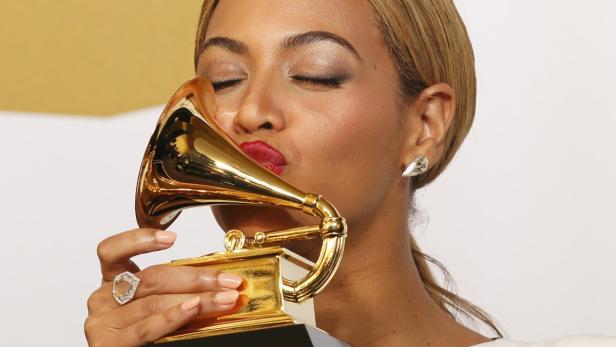 Beyoncé küsst eine goldene Grammy-Trophäe.