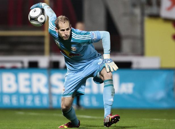 Ein Torwart in hellblauer Uniform fängt einen Ball.