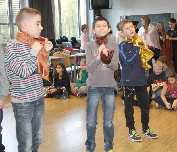 Eine Gruppe von Kindern in einem Klassenzimmer mit glänzenden Schals.