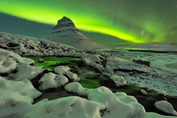 Nordlichter über dem verschneiten Kirkjufell in Island.