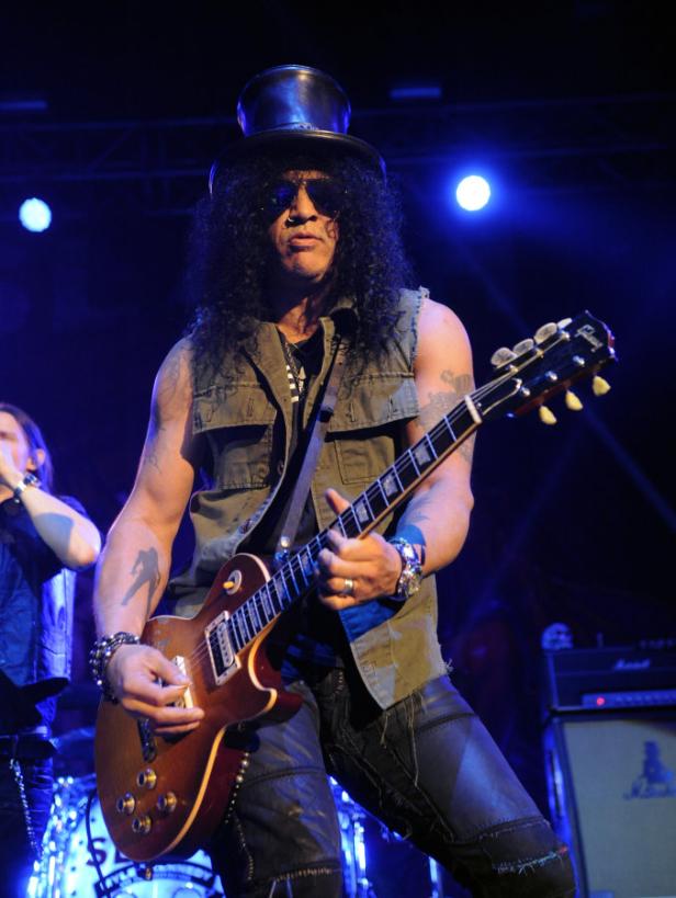Slash, der Gitarrist von Guns N' Roses, tritt in einem schwarzen Zylinder und einer Sonnenbrille auf.