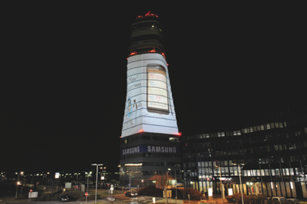 Ein Hochhaus mit einer großen Samsung-Werbung für das Galaxy Note bei Nacht.