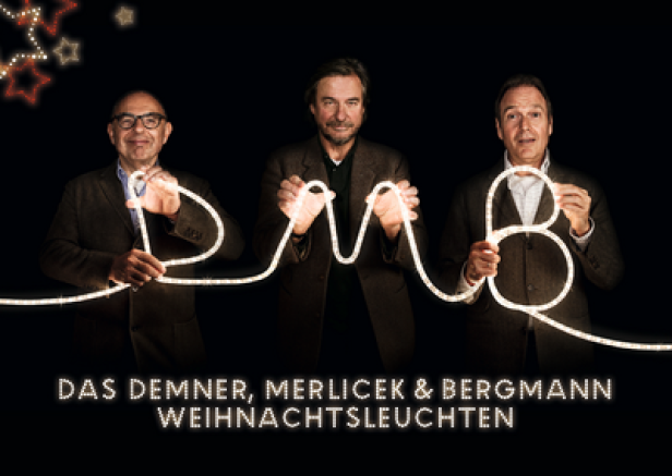 Das Demner, Merlicek & Bergmann Team hält eine leuchtende DMB-Lichterkette.