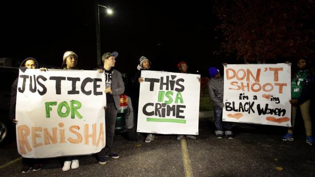 Demonstrators protest the killing of 19-year-old R Eine Gruppe von Menschen demonstriert mit Schildern, die „Justice for Renisha“ und „Don't shoot, I'm a black woman“ zeigen.