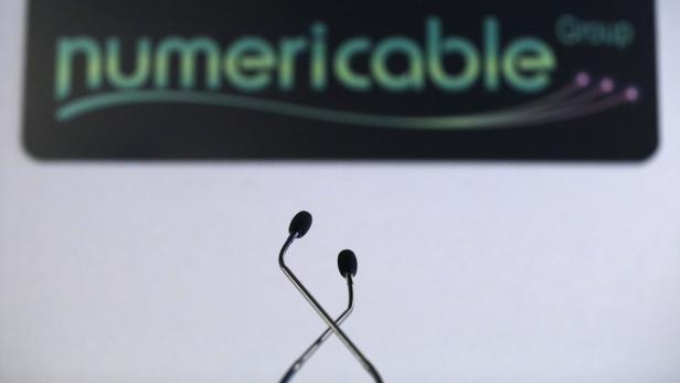 Zwei Mikrofone stehen vor dem Logo der Numericable Group.