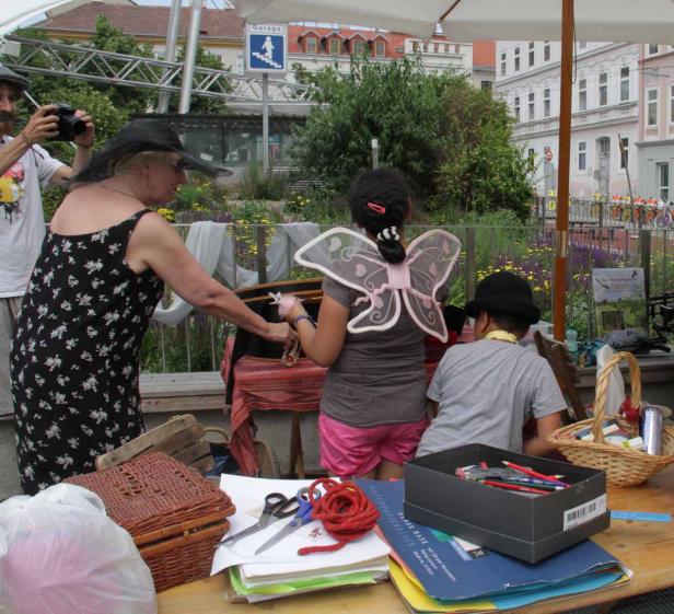 Eine Frau verkauft Puppen an Kinder auf einem Markt im Freien.