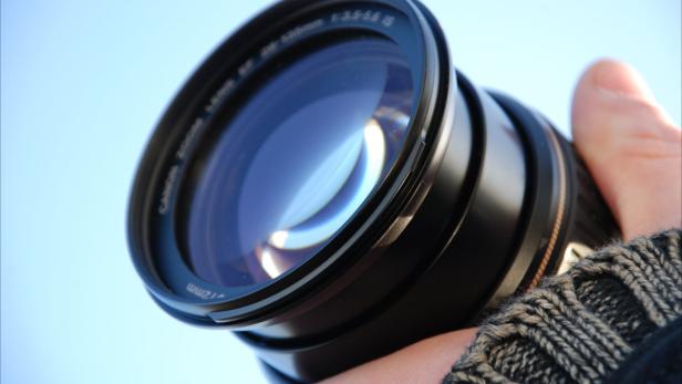 Ein Canon Zoom-Objektiv wird von einer Hand gehalten.