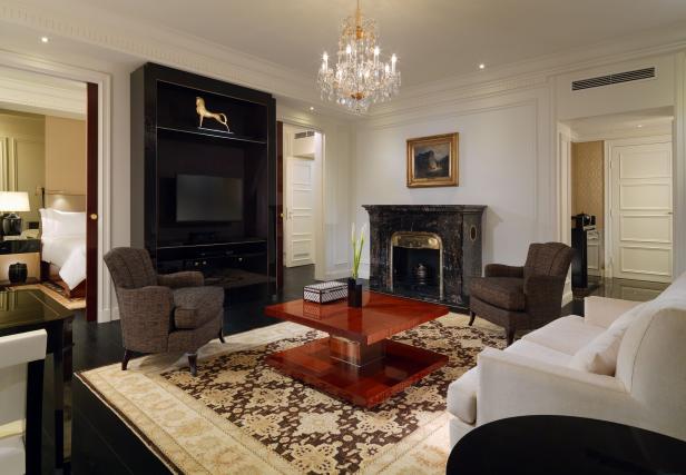 Ein luxuriöses Wohnzimmer mit Kamin, Sesseln und einem Kristalllüster.