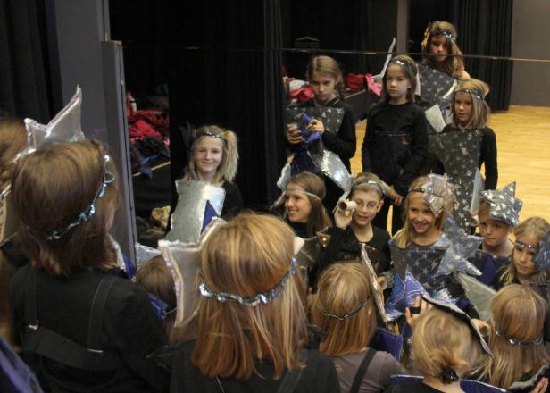 Eine Gruppe Kinder in Kostümen vor einem Spiegel.