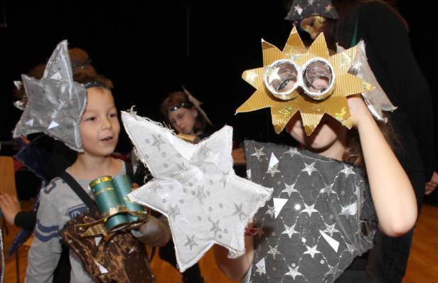 Kinder verkleidet als Sterne und Sonne bei einer Aufführung.