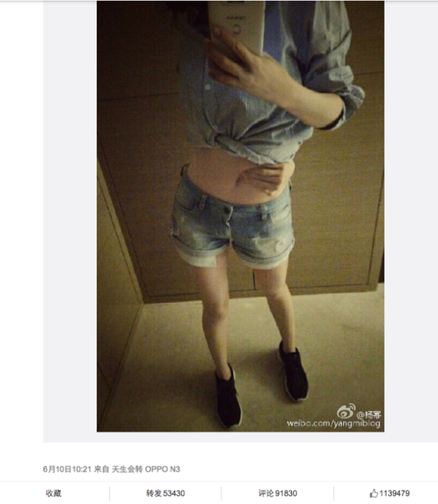 Eine Person macht ein Selfie von ihrem Oberkörper in Jeansshorts und einem Hemd.