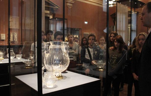 Eine Gruppe von Menschen betrachtet Glaswaren in einem Museum.