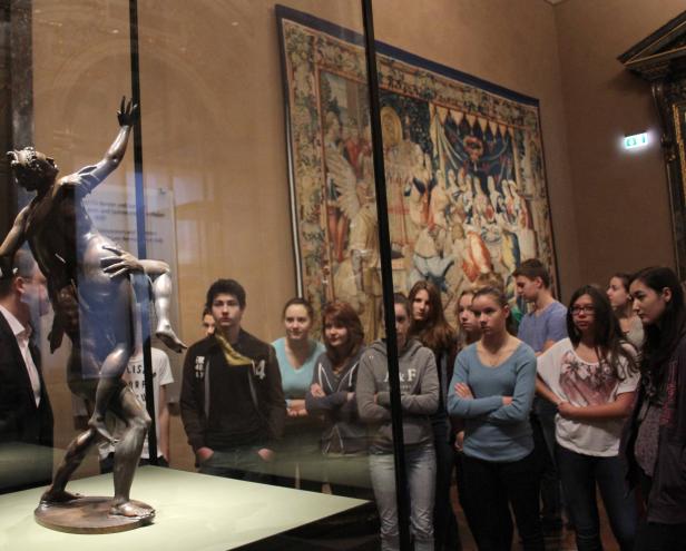 Eine Gruppe von Menschen betrachtet eine Skulptur in einem Museum.