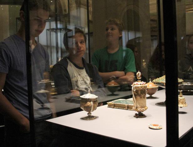 Besucher betrachten eine Vitrine mit historischen Artefakten.