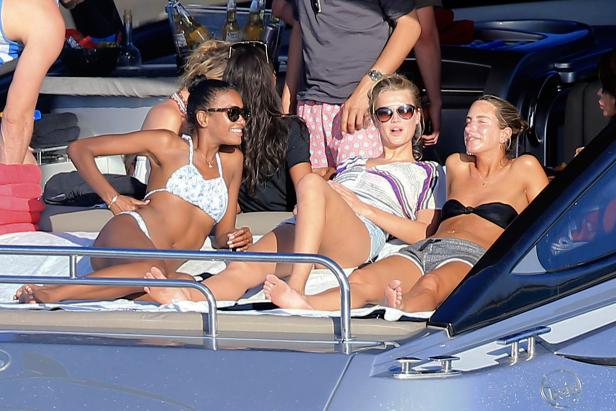 Mehrere Frauen entspannen sich auf einer Yacht in der Sonne.
