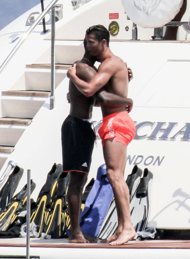 Zwei Männer umarmen sich auf dem Deck einer Yacht.