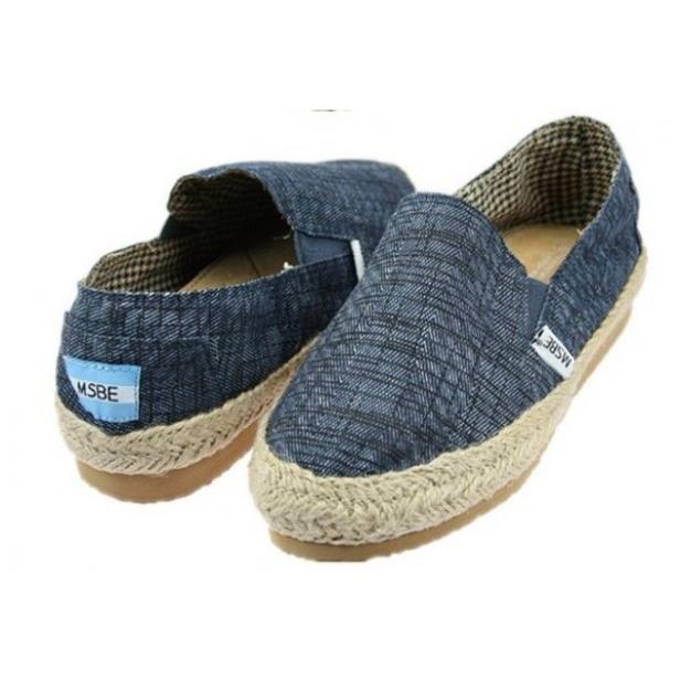 Ein Paar blaue Stoff-Espadrilles mit Bastsohle stehen nebeneinander.