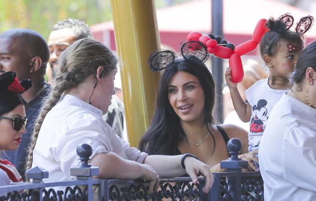 Kim Kardashian mit Familie im Disneyland, alle tragen Mickey-Mouse-Ohren.