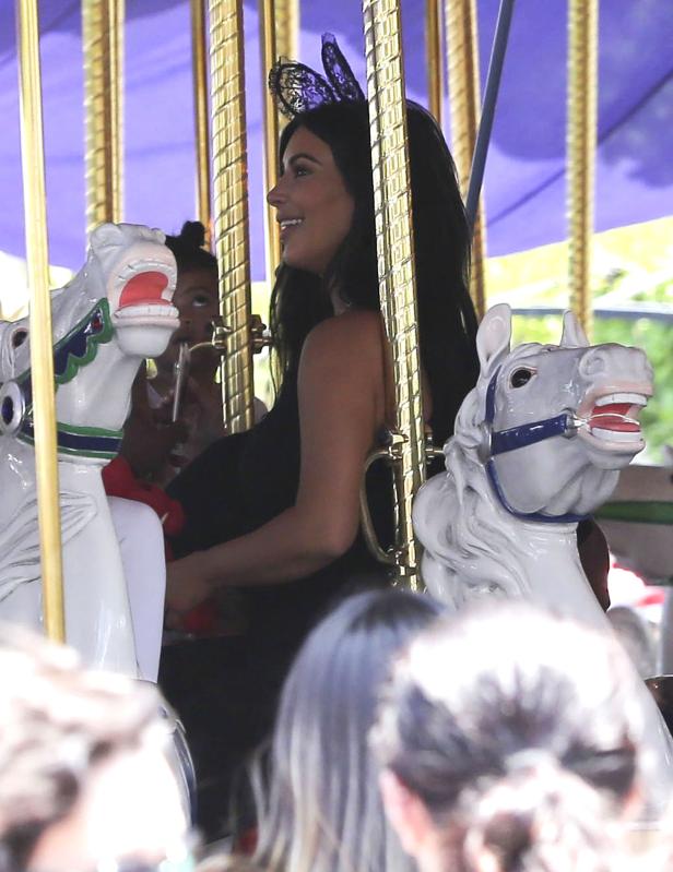 Kim Kardashian fährt mit ihrer Tochter Karussell.