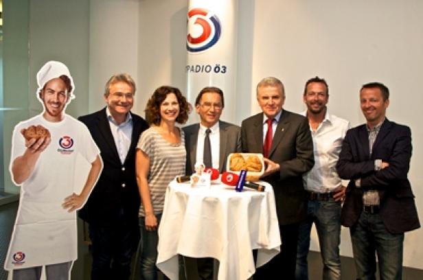 Rainer Reichl (Reichl und Partner), Sandra König (Ö3-Moderatorin), Wolfgang Hofer (Pan&Co), Peter Augendopler (backaldrin), Robert Kratky, Georg Spatt (Ö3-Senderchef) (c: apa/lusser) Eine Gruppe von Personen posiert vor dem „Radio Ö3“-Logo mit einem Tisch und Gebäck.