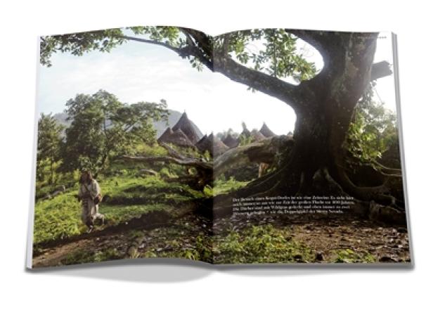 Terra Mater - Magazin - Erstausgabe 1 - Juni 2012 - Red Bulletin Verlag Ein Mann wandert durch eine grüne Landschaft mit traditionellen Häusern im Hintergrund.