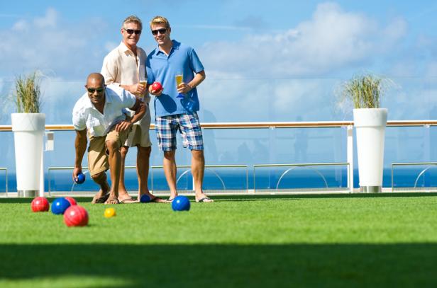Drei Männer spielen Boccia auf dem Deck eines Kreuzfahrtschiffes.