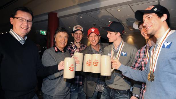 Eine Gruppe von Männern hält Bierkrüge der Marke Stiegl in die Kamera.
