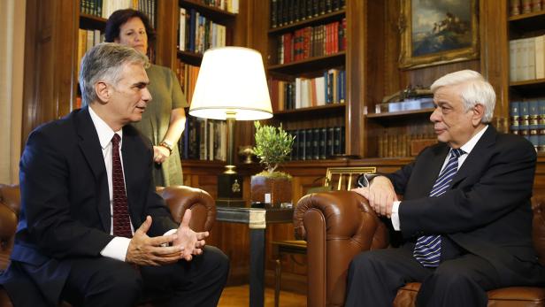 Zwei Männer sitzen in einem Arbeitszimmer und unterhalten sich.