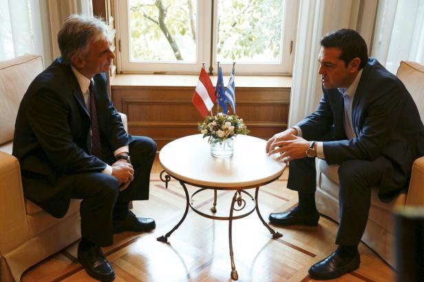 Zwei Männer in Anzügen sitzen sich gegenüber und unterhalten sich.