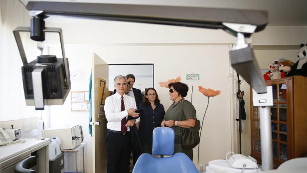 Eine Gruppe von Personen steht in einem Behandlungsraum einer Zahnarztpraxis.