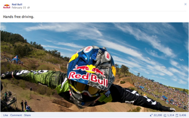 Red Bull - Facebook.com/redbull Ein Red Bull Athlet fährt freihändig ein Downhill-Rennen vor einer Zuschauermenge.