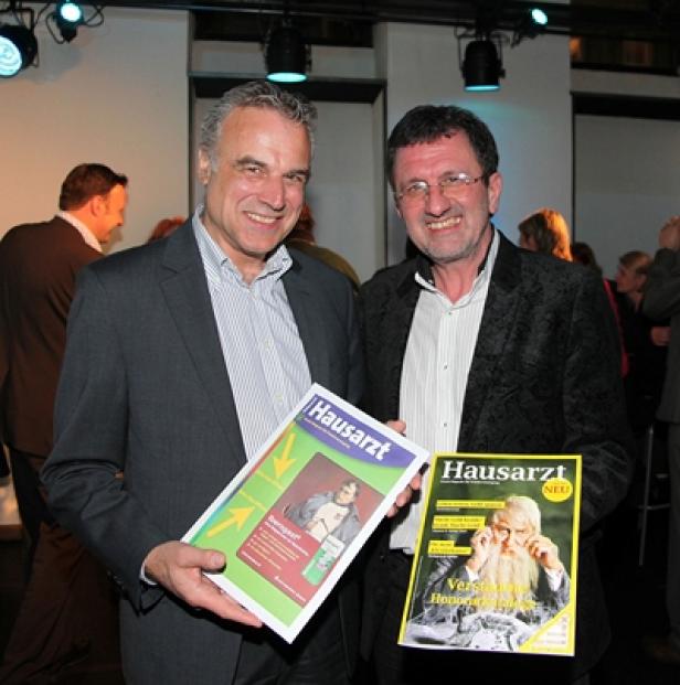 Zwei Männer halten Ausgaben der Zeitschrift „Hausarzt“ in die Kamera.