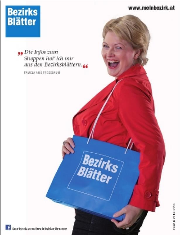 Eine Frau mit roter Jacke hält eine blaue Tasche der „Bezirksblätter“.
