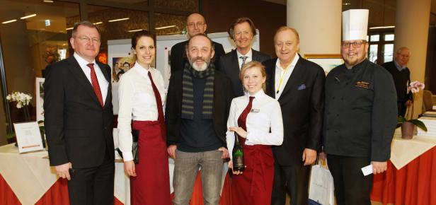 Eine Gruppe von Personen posiert für ein Foto in einem Innenraum.