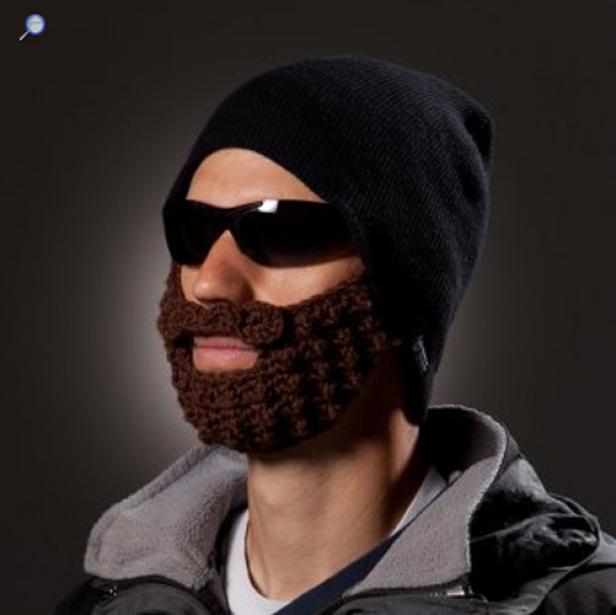 Ein Mann mit Sonnenbrille und einer schwarzen Mütze mit angehäkelten, braunen Bart.