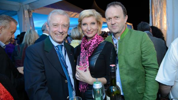 Drei Personen posieren auf einer Veranstaltung für ein Foto.