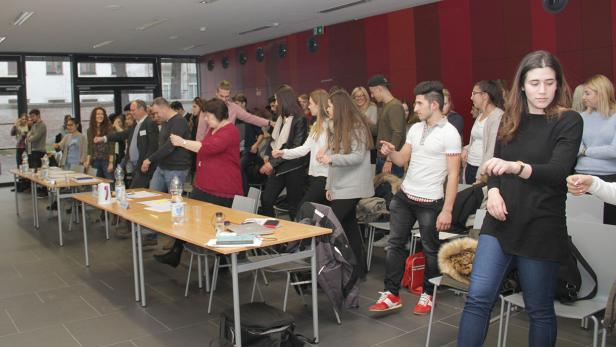 Eine Gruppe von Menschen nimmt an einer Übung in einem Konferenzraum teil.