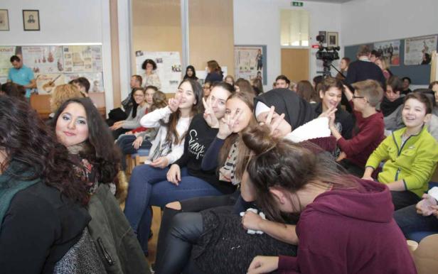 Eine Gruppe von Schülerinnen und Schülern sitzt in einem Klassenzimmer.