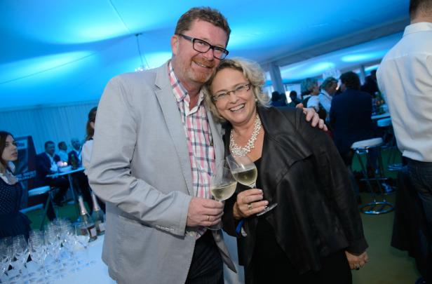 Ein Mann und eine Frau stoßen auf einer Party mit Weißwein an.