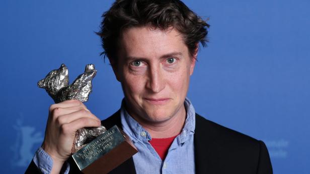 Ein Mann hält einen silbernen Bären, die Trophäe der Internationalen Filmfestspiele Berlin.