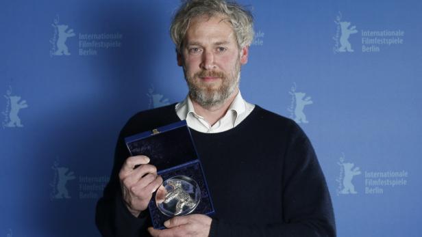 Ein Mann hält einen silbernen Bären der Internationalen Filmfestspiele Berlin in einer blauen Schatulle.