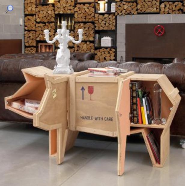 Ein Schwein-förmiger Tisch aus Holzkisten steht in einem Wohnzimmer.