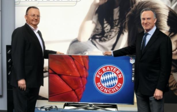 Hans Wienands ( Senior Vice President Samsung Electronics), Karl-Heinz Rummenigge (CEO FC Bayern München AG) (c: samsung electronics deutschland) Zwei Männer präsentieren einen Fernseher mit dem Logo des FC Bayern München.