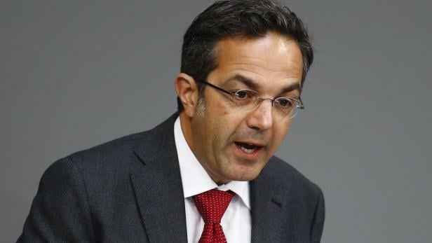 Ein Mann mit Brille, Anzug und roter Krawatte spricht.