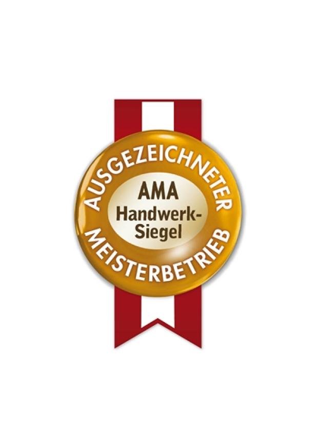 AMA Handwerksiegel - Lebensmittelakademie des Gewerbes - straberger conversations Ein goldenes AMA Handwerk-Siegel „Ausgezeichneter Meisterbetrieb“ an einem roten Band.